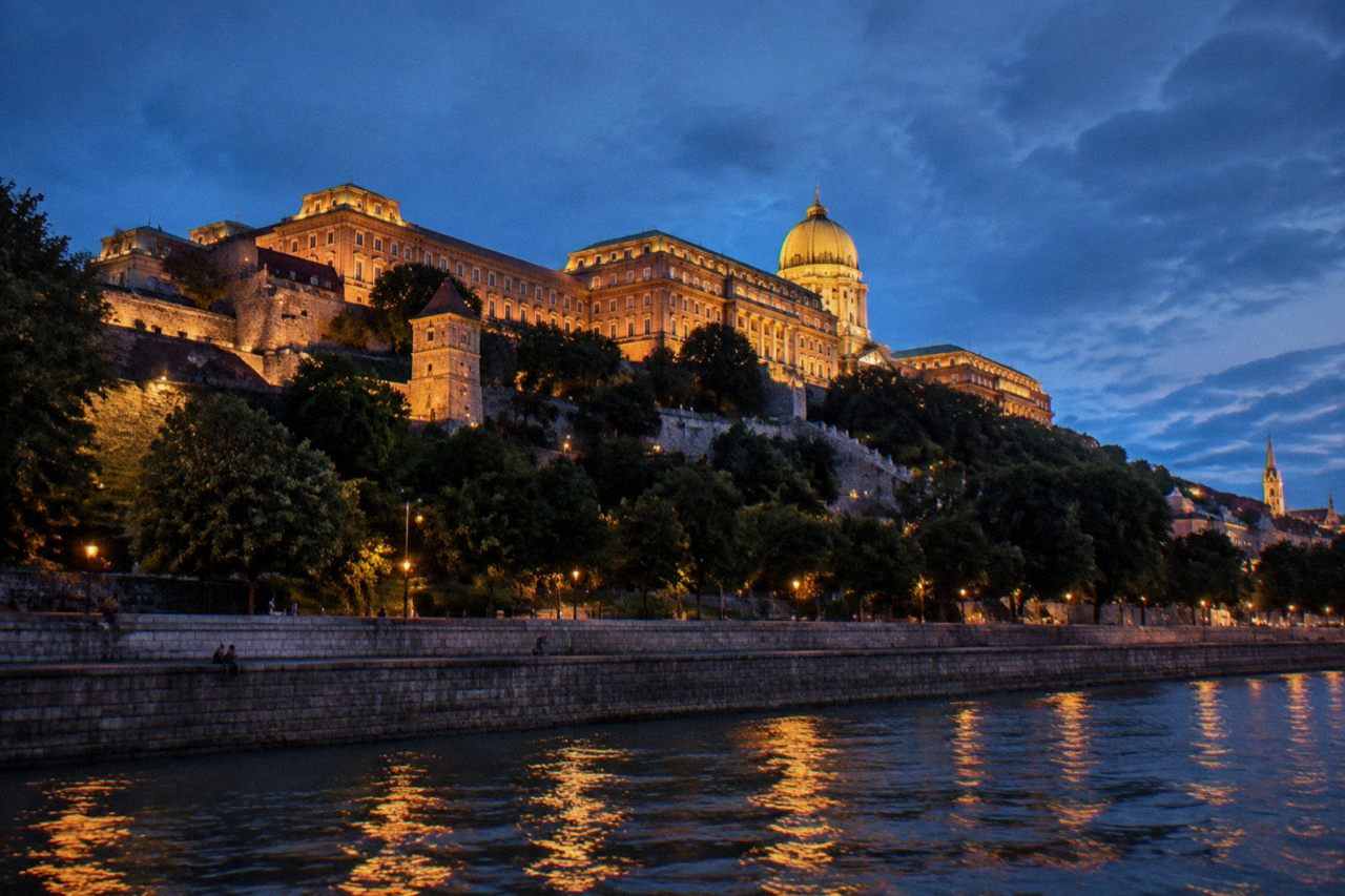 Stone walls and towers of Buda Castle Hill rising above the Danube at dusk