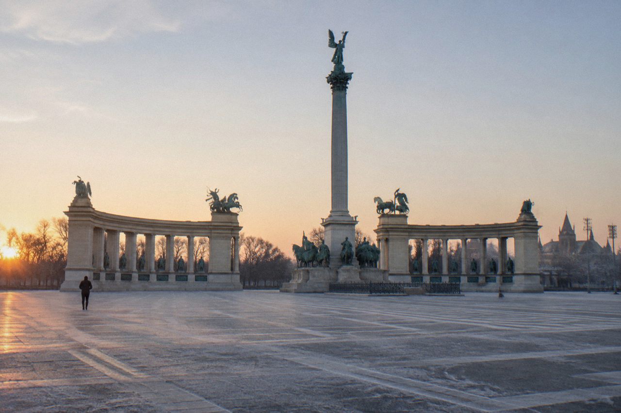 Empty historic Budapest square with ornate facades and tram tracks in soft morning light