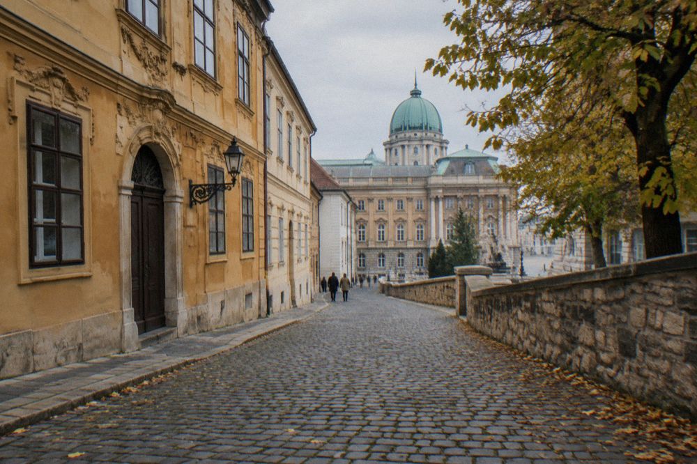 A quiet lane on Castle Hill with restored historic facades leading toward the palace courtyards