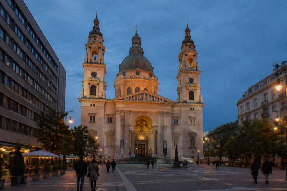 Wide Budapest street with the basilica dome lit against the night sky