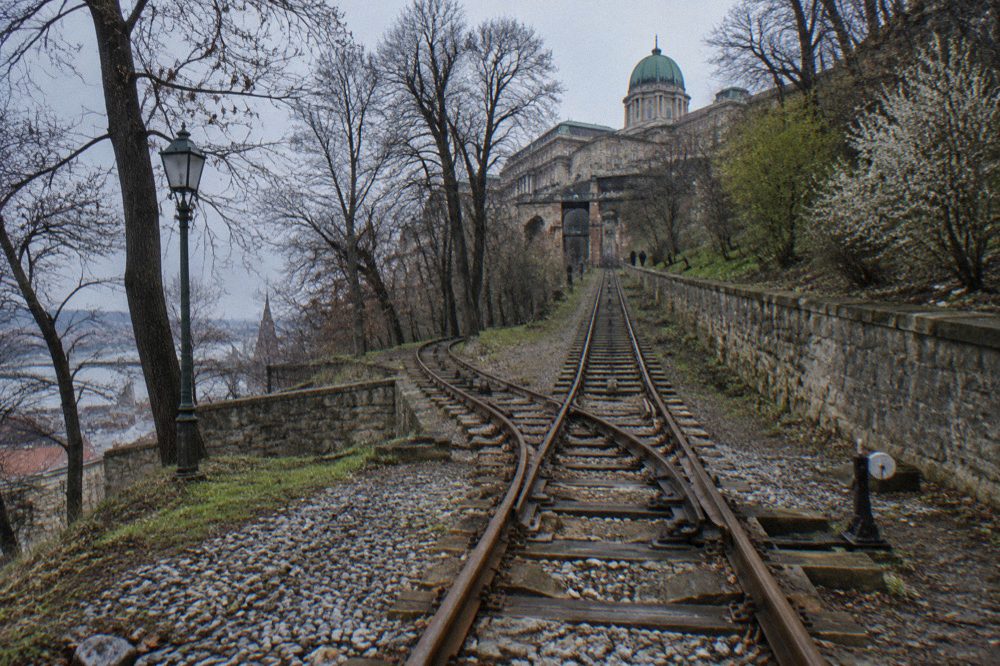 Historic funicular railway track climbing the wooded slope toward Castle Hill in Budapest