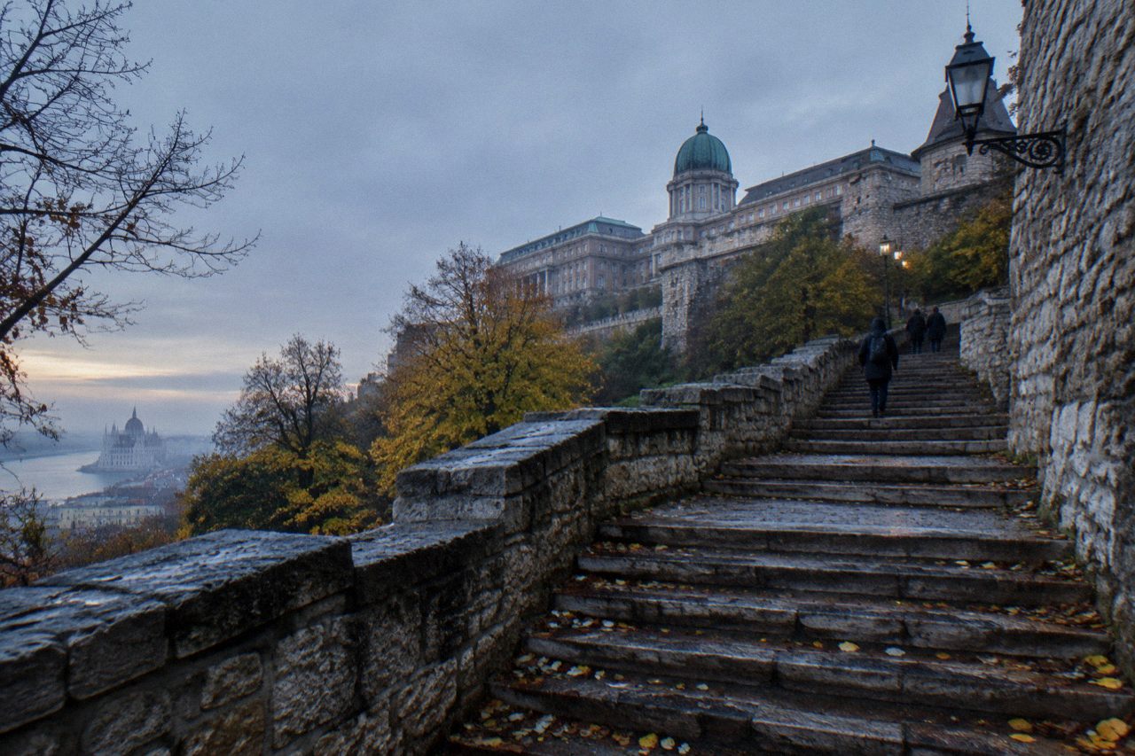 Stone staircase and historic rampart walls rising toward Buda Castle on Castle Hill in Budapest