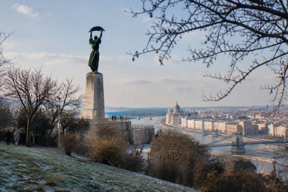 The Liberty Statue standing on Gellert Hill above the city skyline, seen from the Citadella park.