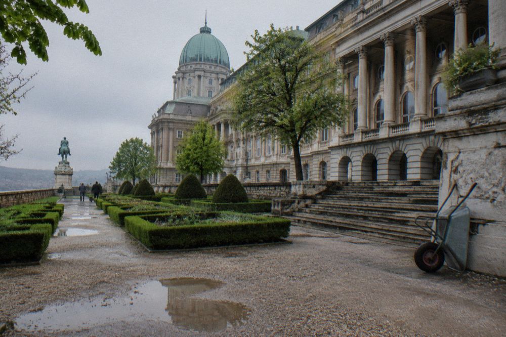 The colonnaded facade of the Hungarian National Museum behind its stone steps and garden.