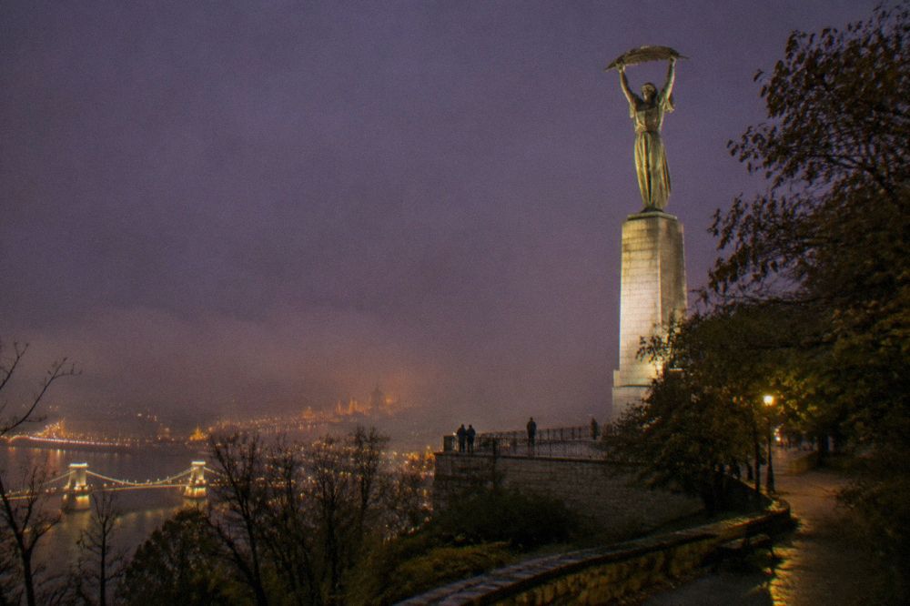 The Liberty Statue on Gellért Hill lit against the night sky above Budapest
