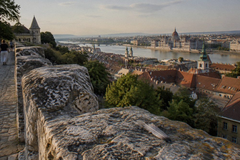 Stone ramparts and tiled rooftops of the Castle District seen from a hillside terrace