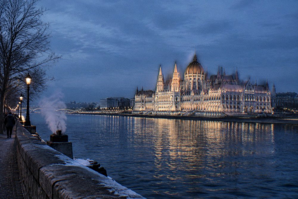 The illuminated Parliament building reflected in the Danube on a cold evening