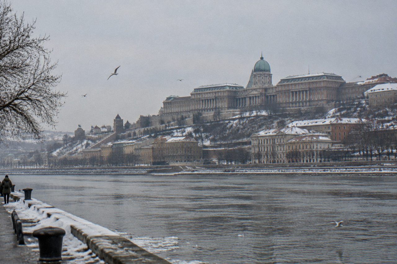 Snow on the rooftops and domes of Buda Castle Hill rising above the Danube in winter