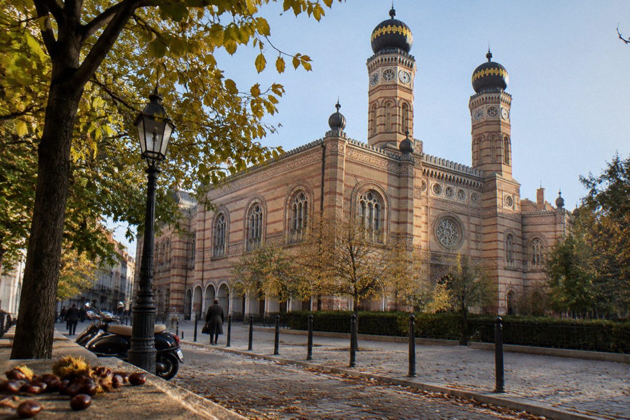 Grand synagogue facade with twin domed towers above a Budapest street