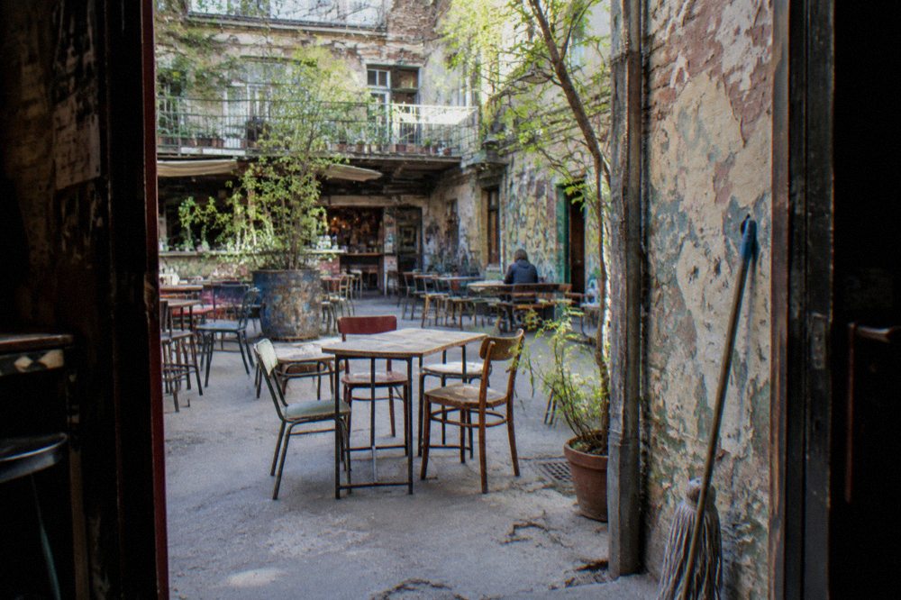 A ruin bar courtyard with mismatched vintage furniture and warm string lights