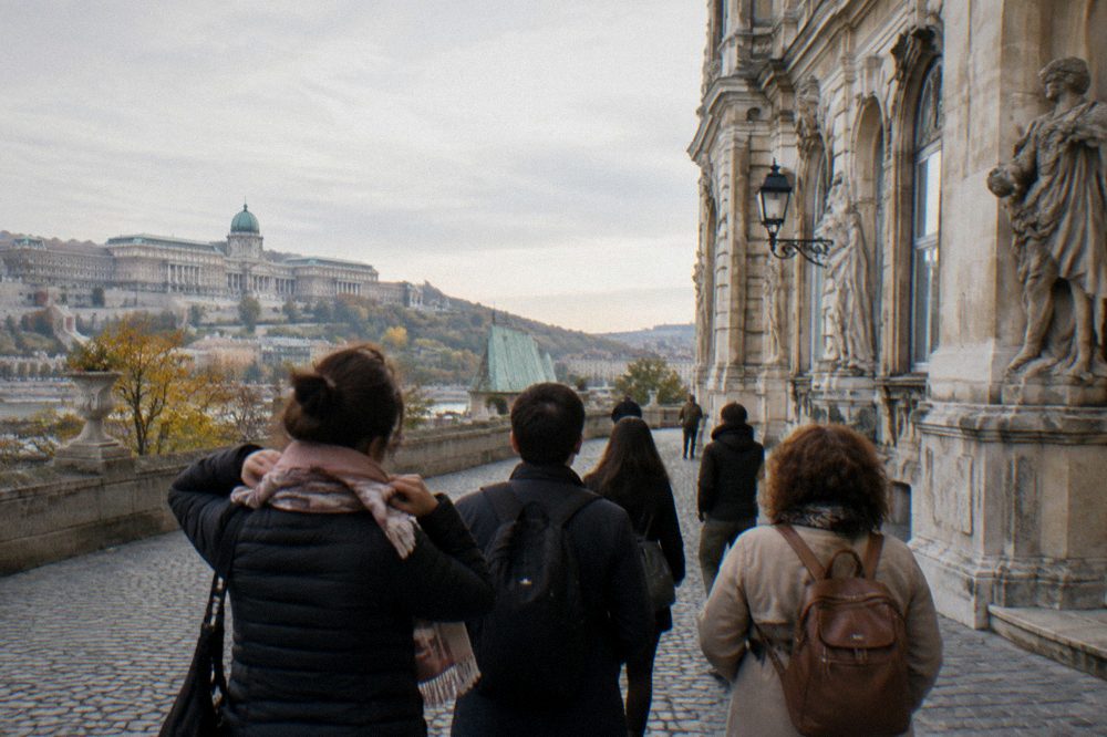 Guides and visitors gathered in a Castle District square before a walking tour